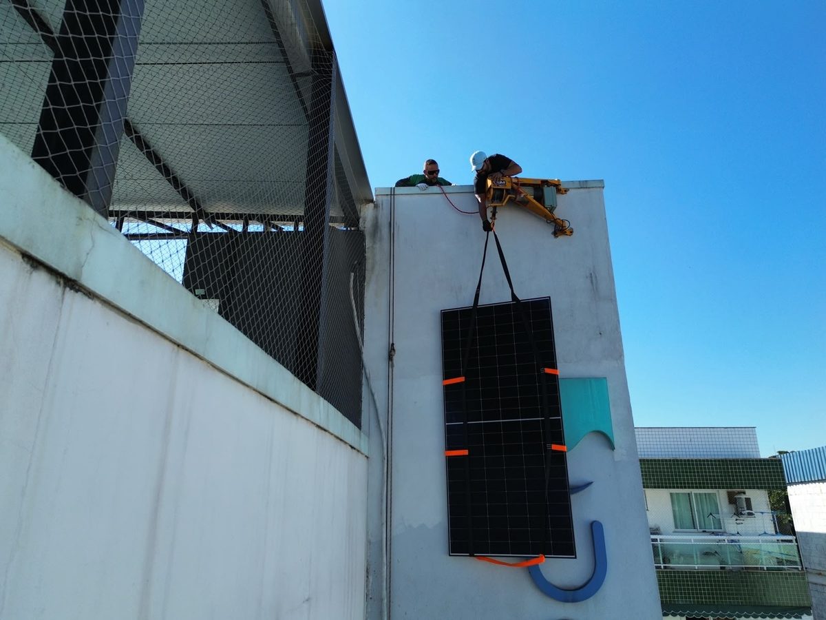 Equipe da P&G instalando painel solar com içamento