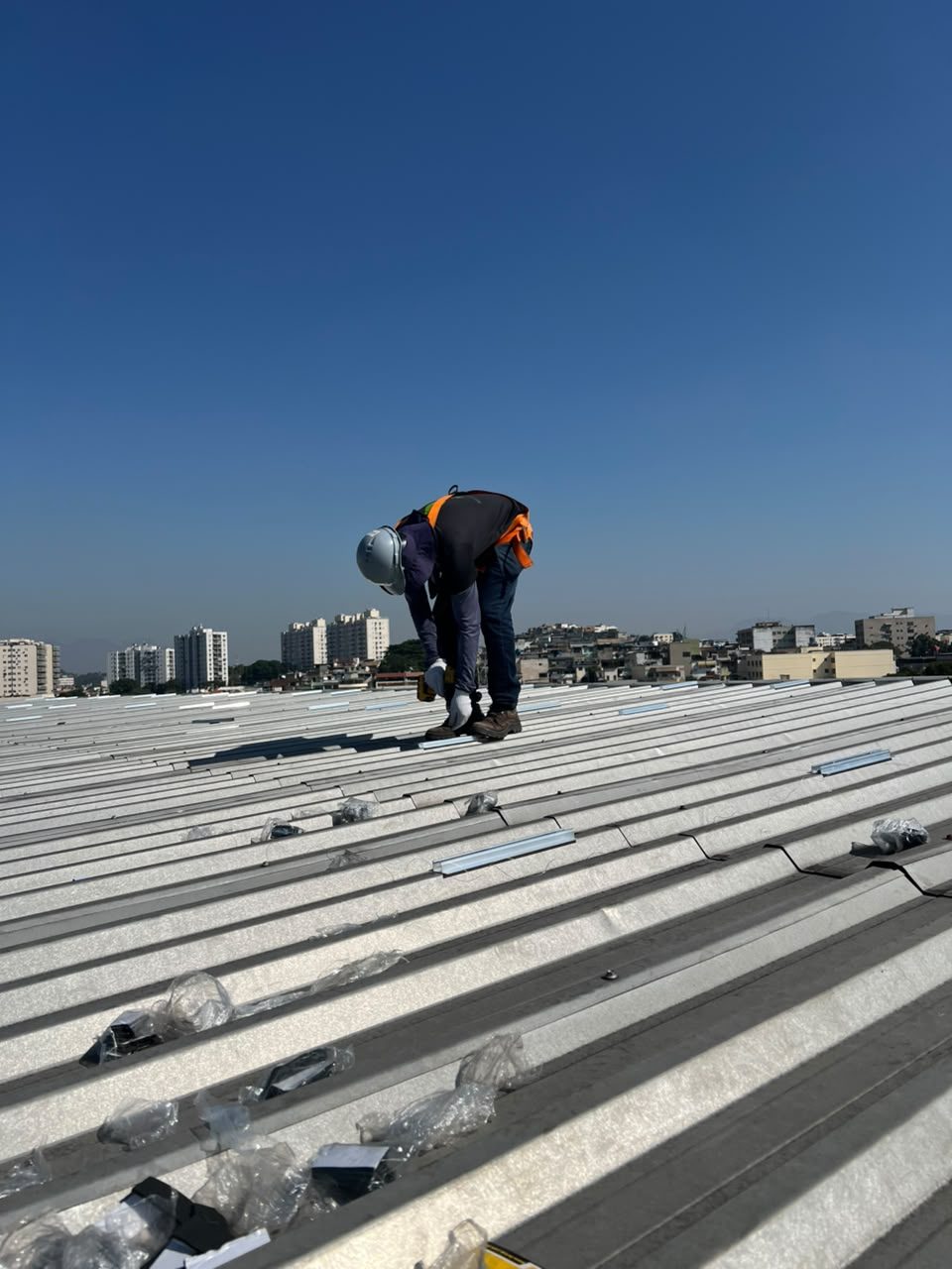 Técnico instalando estrutura de fixação em telhado metálico